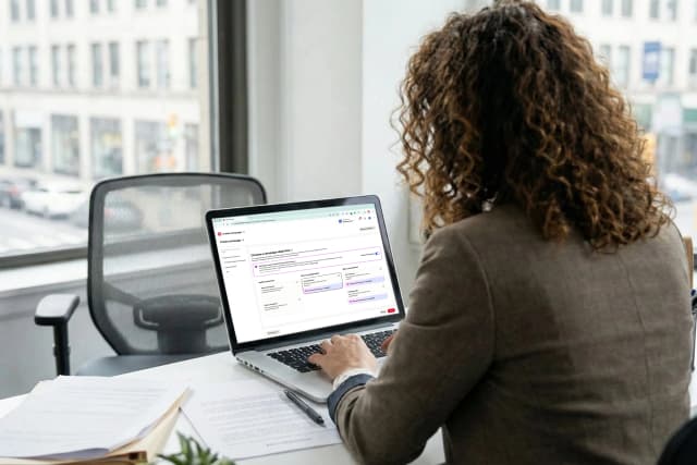Professional working on a laptop setting up a digital advertising campaign on Pinterest in an office.