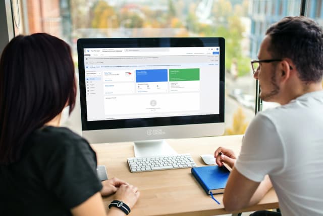 Two professionals reviewing Google Tag Manager setup on a desktop computer.