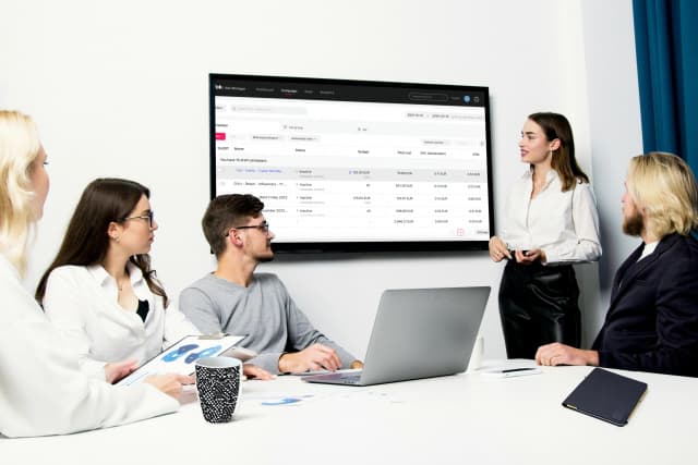 Instructor presenting TikTok advertising campaign results to a team in a meeting room.
